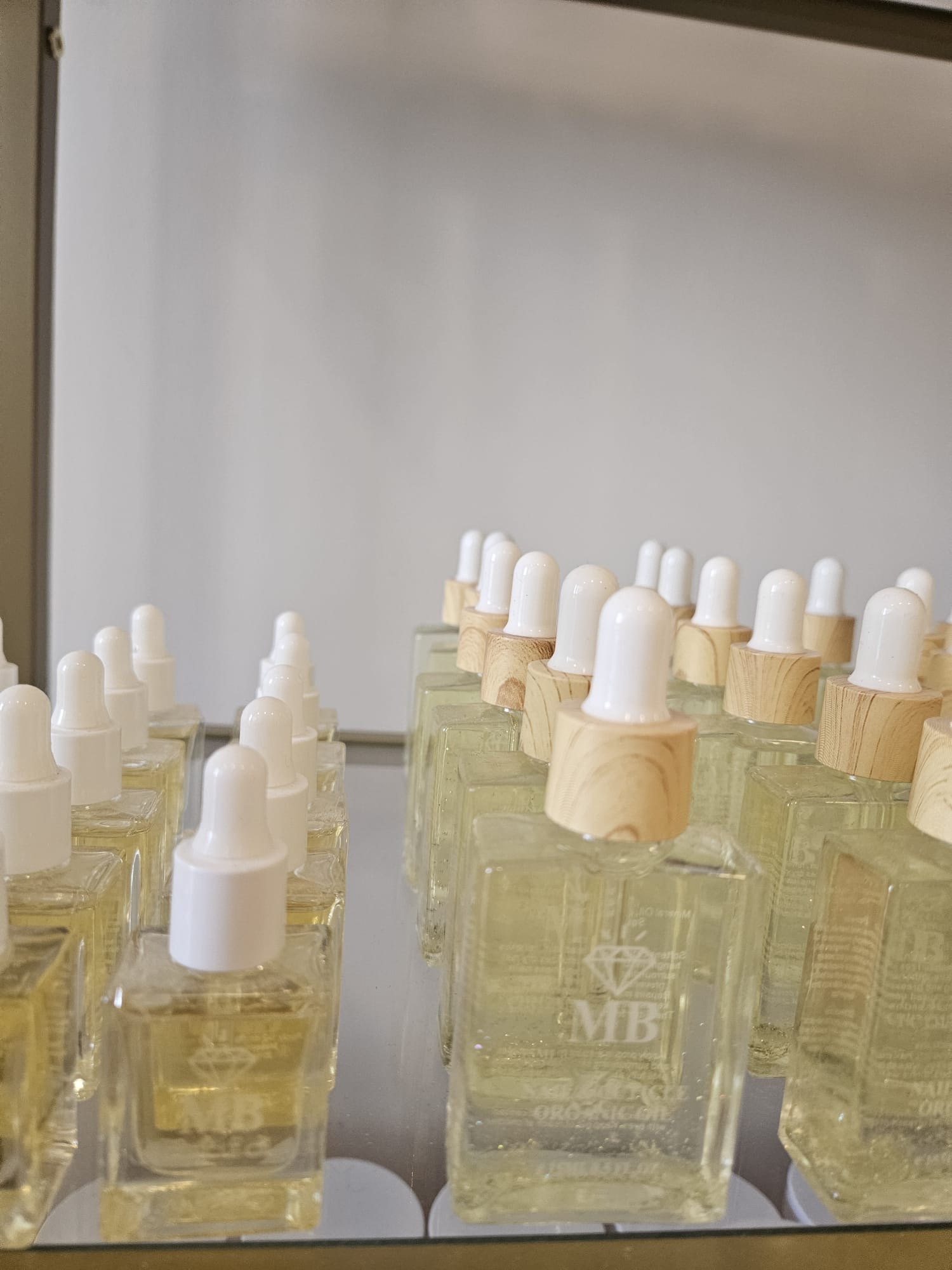 MB nagelolja i glasflaskor på spegelhylla hos MB Beauty Love