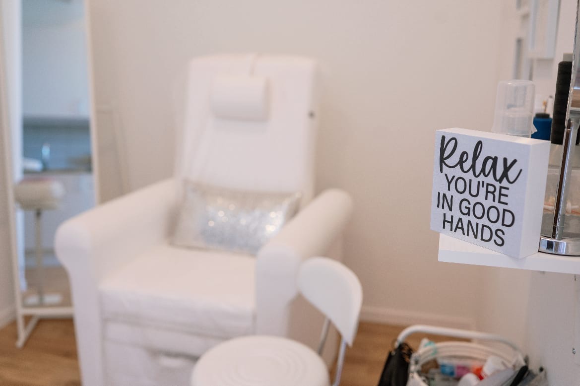 Skylt med texten Relax you're in good hands vid behandlingsstolen hos MB Beauty Love
